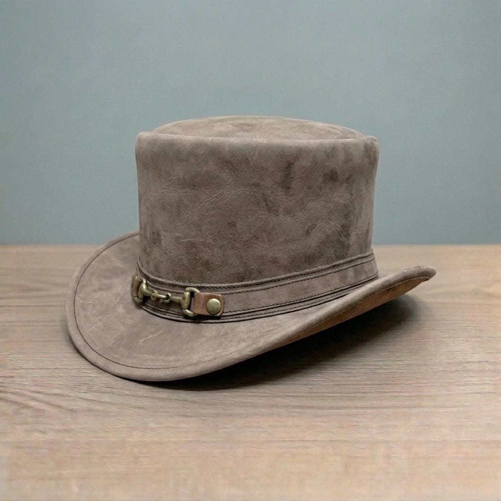 May include: A brown suede top hat with a wide brim. The hat has a decorative band with a metal buckle and leather details. This classic hat is suitable for formal events or costume use. The hat's dimensions are in centimeters.